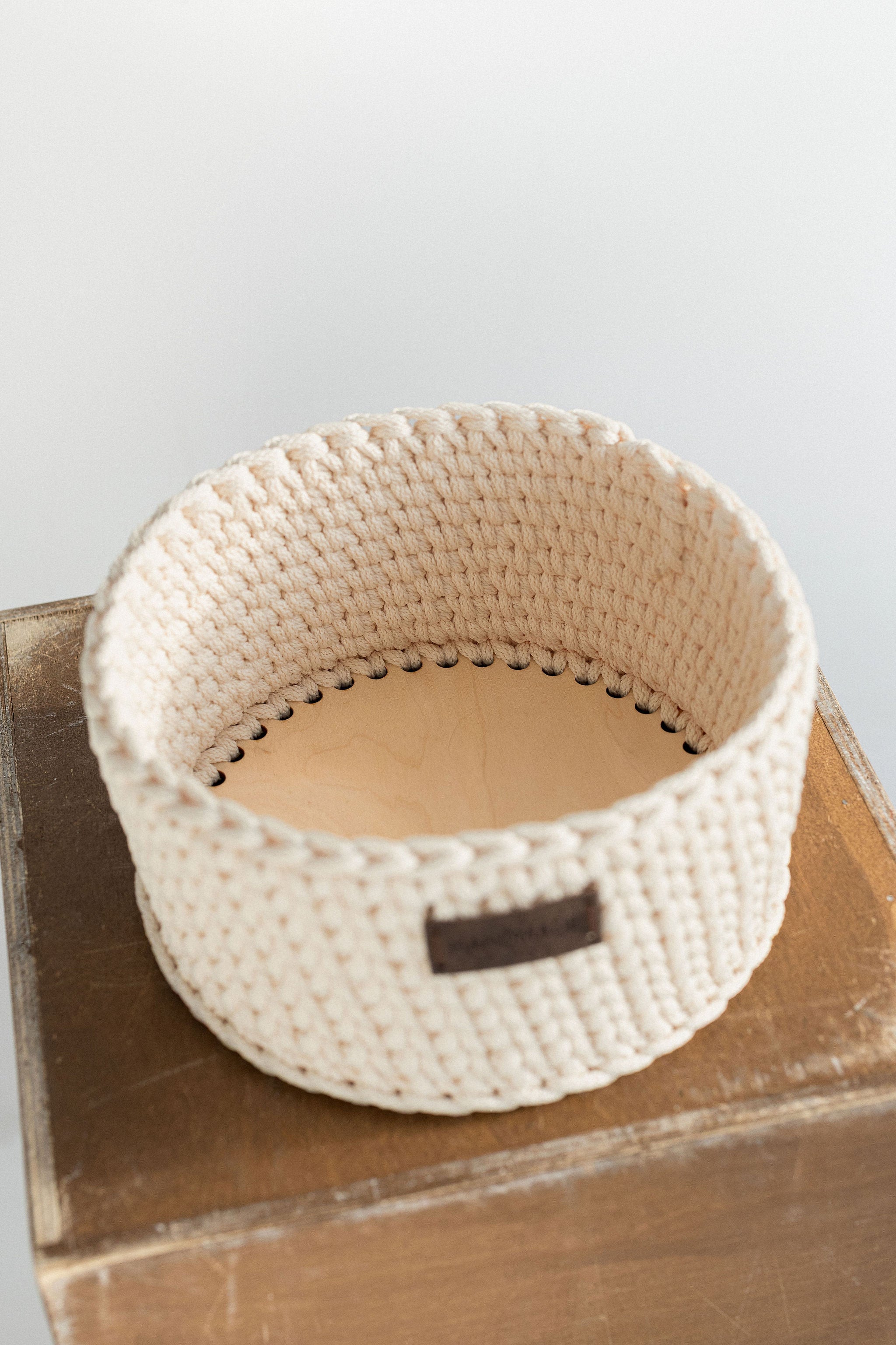 Handmade ivory crochet basket with leather label and wooden base