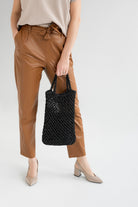 Black crochet beach bag in hands