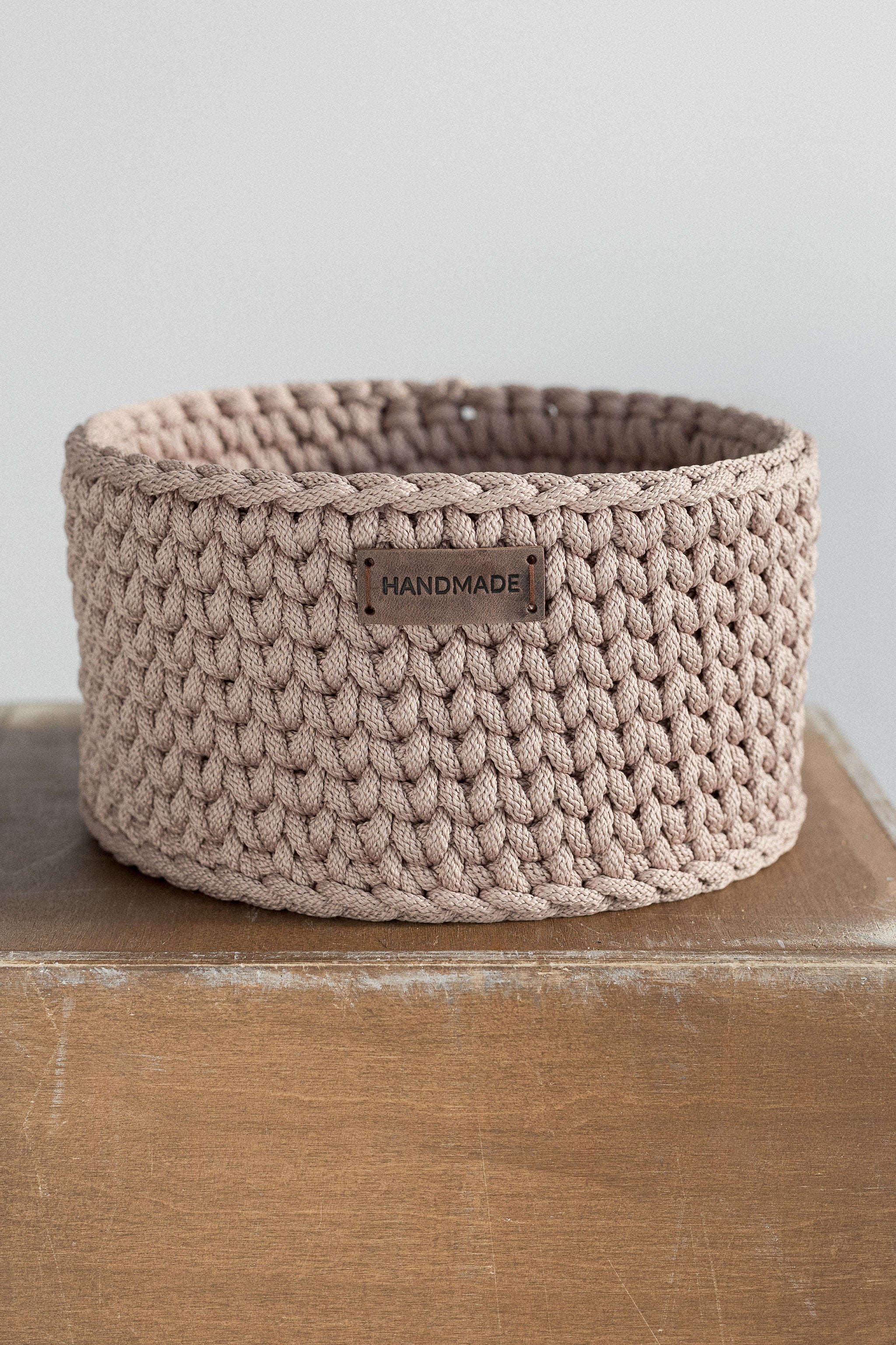 Beige crochet basket with wooden base